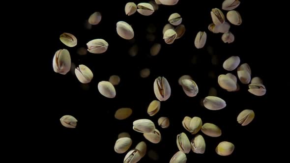 Delicious Salted Pistachios are Bouncing on a Black Background