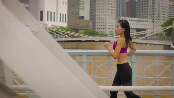 Middle-aged Asian woman jogging in the rain in Singapore 