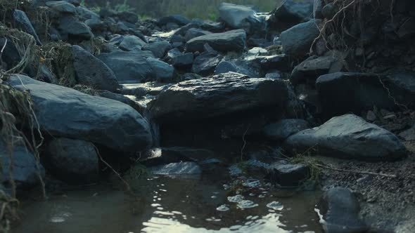 A small stream flowing down from the bed of rocks in Beach de Serra de Dentro