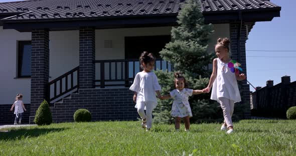 Little Girls Walk With Her Sister In The Courtyard Of The House