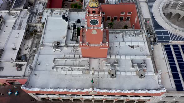 Aerial camera backing away and pitching up creating a parallax of the clock tower over the Municipal