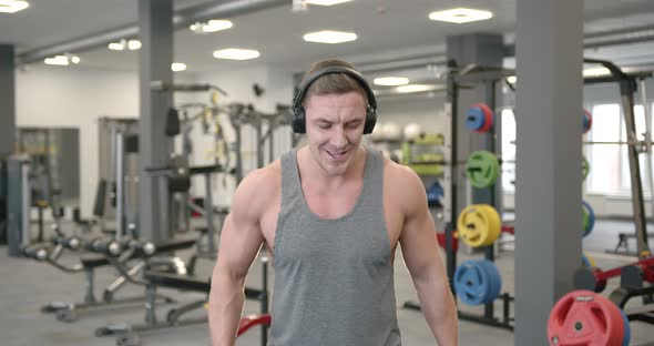 Sporty Man Exercise with Dumbbells at Gym