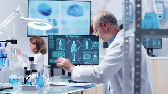 Adult Male Researcher Looking at Samples in Tubes alt