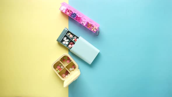 Top View of Medical Pills in a Pill Box on Color Background