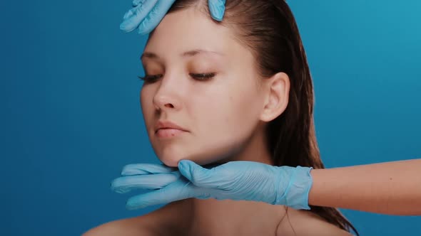 Cosmetology Doctor Touching Woman Face Before Cosmetic Surgery on Blue Background