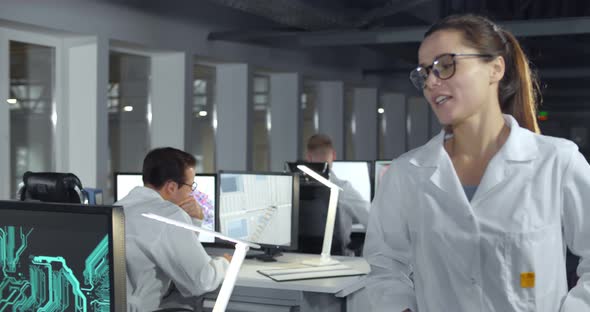 Woman Scientist in White Coat Walking in Lab and Sitting at Her Workplace