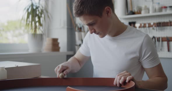 Leather Worker Burnishing Edge Leather Belt During Manufacturing Process