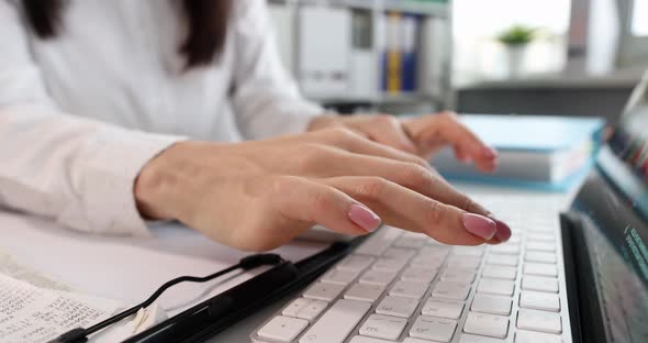 Female Hands in Office Typing on Laptop Keyboard Closeup