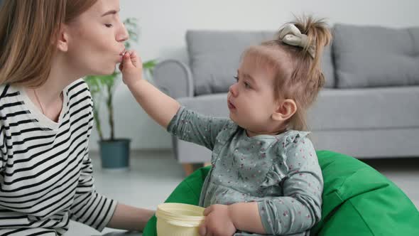 Motherhood Cute Little Daughter Feeds Her Mom with Sweet Grapes Caring Female Parent Kiss Little