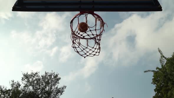 Orange Basketball Ball Miss the Basket Not Hitting Target in Slow Motion in Front of Cloudy Sky