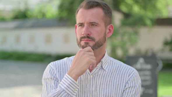 Outdoor Portrait of Pensive Middle Aged Man Thinking