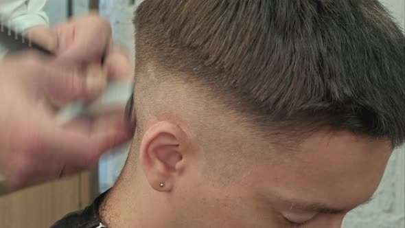 Hairdresser Cutting with Trimmer Hair of Man Client at Beauty Parlour