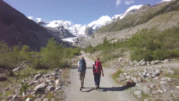 Two Friends During A Alpine Trek Towards A Glacier