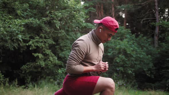 Young Asian Man Warming Up at Forest Road Before Jogging