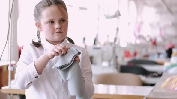 Little Girl Standing in the Factory with a Thread