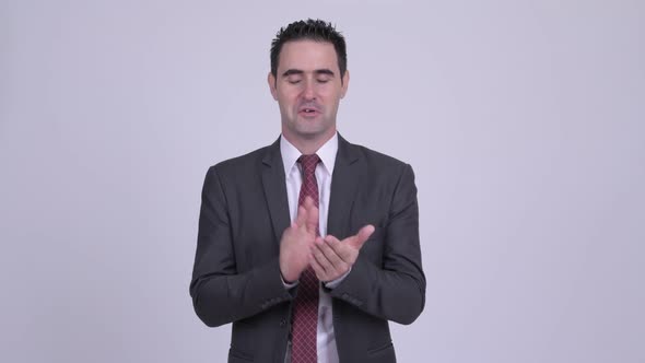 Happy Handsome Businessman Clapping Hands Against White Background