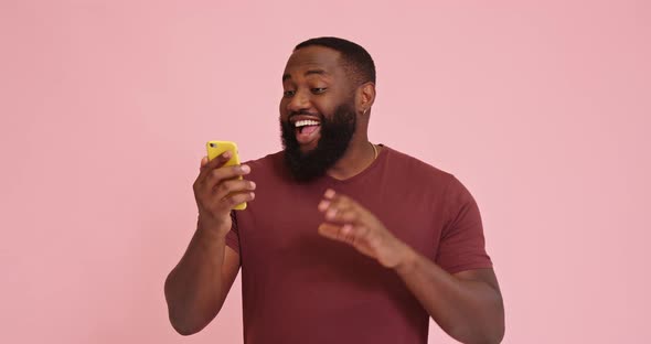 Young African American Man Make Video Call Isolated on Pink Background