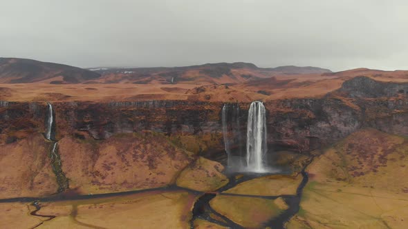 Panorama of dry field with waterfall