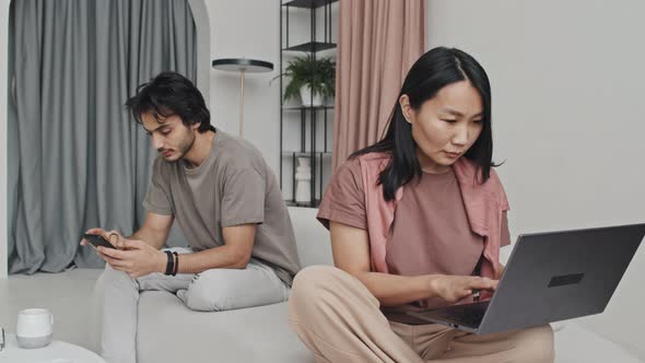 Woman and Man Using Devices on Couch