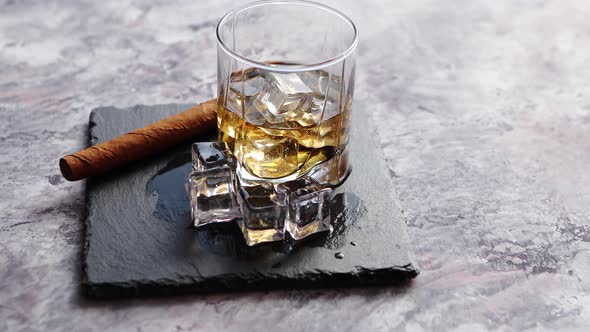 Glass of Whiskey with Ice Cubes and Cigar