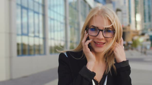 Beautiful Business Woman Blond In Glasses Walks Street Of The City