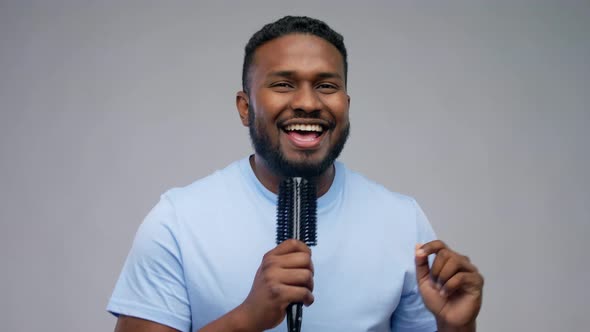 Happy African American Man with Hairbrush Singing