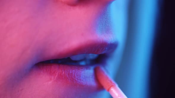 Close Up Shots of a Beautiful Girl Putting on Neon UV Makeup on Mouth Lips and Eyes Before Going Out