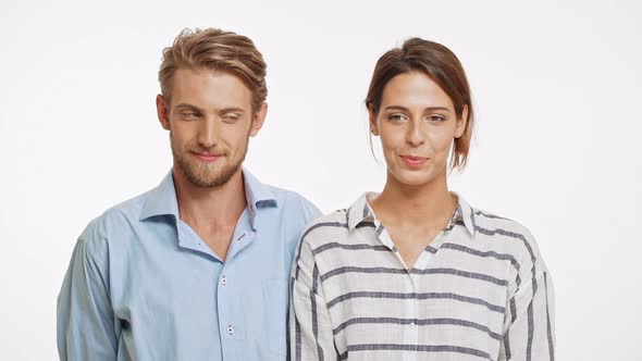 Beautiful Caucasian Pair Standing Flirting Ogle Smiling Laughing on White Background in Slowmotion