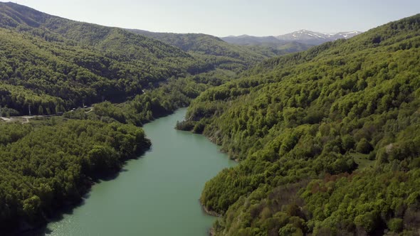 Aerial flyover, slow tilt down over lake formed by Maneciu Dam, Romania