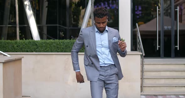 Handsome Afro American Man with Wireless Headphones Having Good Mood and Dancing at Street. Stylish