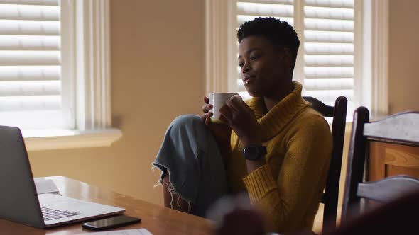 African american woman drinking coffee while working from home