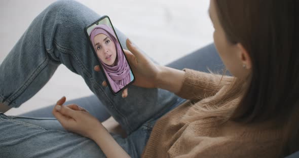 Female Using Medical App on Smartphone Consulting with Arab Muslim Woman in Hijab Doctor Via Video