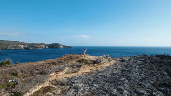 Girl Standing on a Cliff and Looking at the Sea. Bali, Indonesia