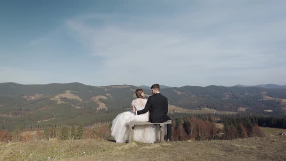 Newlyweds. Caucasian Groom with Bride on Mountain Slope. Wedding Couple. Happy