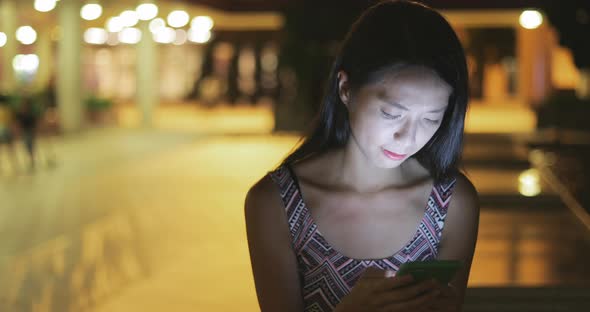 Woman concentrate on using mobile phone at night 