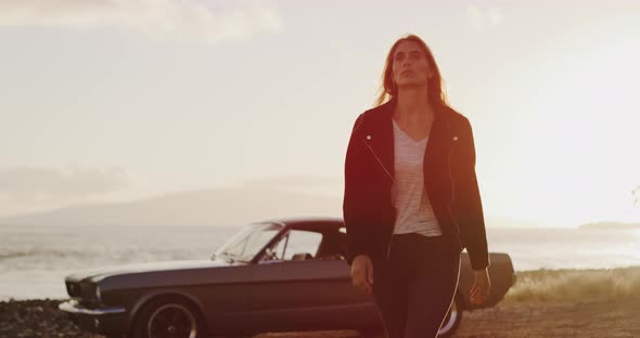 Beautiful woman walking away from a vintage car