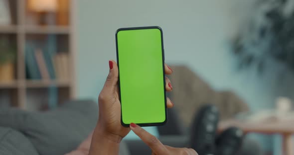 African American Woman Holding Smartphone with Green Mock Up Screen