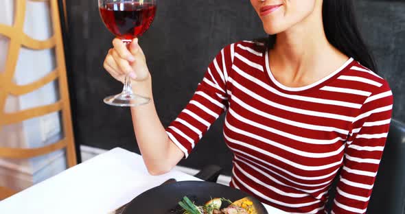 Smiling mature woman drinking red wine