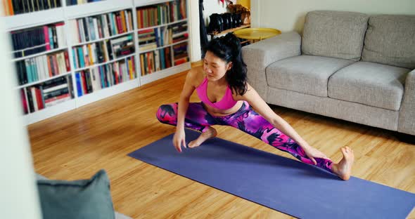 Beautiful woman practicing yoga in living room