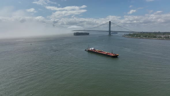 An aerial view of Gravesend Bay in Brooklyn, NY on a cloudy day with blue skies. A dense fog is over