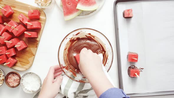 Step by step. Dipping watermelon cubes into melted chocolate and garnishing with sea salt and almond