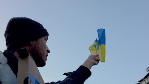 Protester waving Ukrainian flag at demonstration against war, Prague.