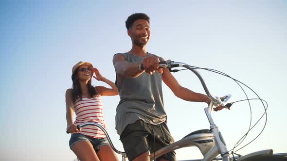 Portrait of a Mixed Race Couple on Tandem Bicycle Outdoors Near the Sea Slow Motion