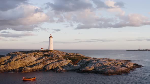 Lille Torungen Lighthouse with Wooden Boat in front Of The Island Of Arendal Torungen, Norway. Aeria