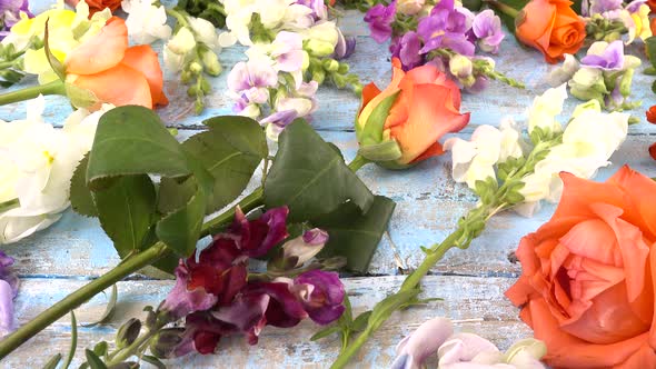 Colorful summer garden flowers: dragon flowers, roses, sweet pea on the vintage wooden