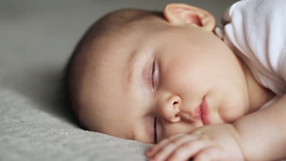 Sleeping Cute Baby Boy on Gray Blanket