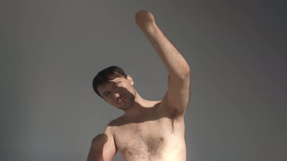 Man with Bare Torso and Amputated Hands Hides From Sunlight