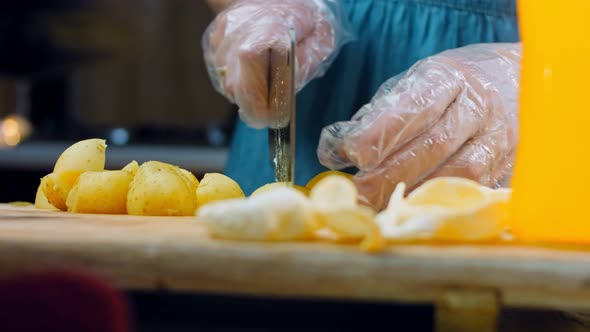 The Chef Cuts the Freshly Boiled Potatoes with a Professional Knife