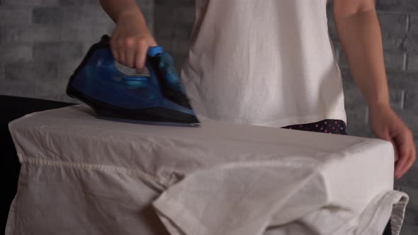 Woman Ironing Clothes on Ironing Board Closeup