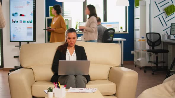 Manager Woman Holding Laptop Looking on Internet While Sitting on Couch Smiling